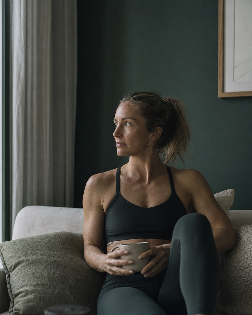 Femme au repos sur son canapé, une tasse à la main